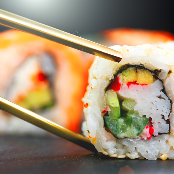 Chopsticks picking up sushi close up